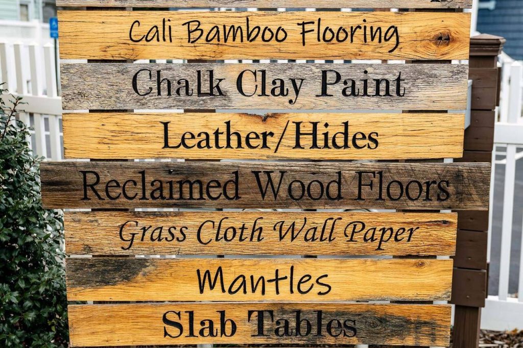 Wooden sign listing flooring, paint, leather, & decor products